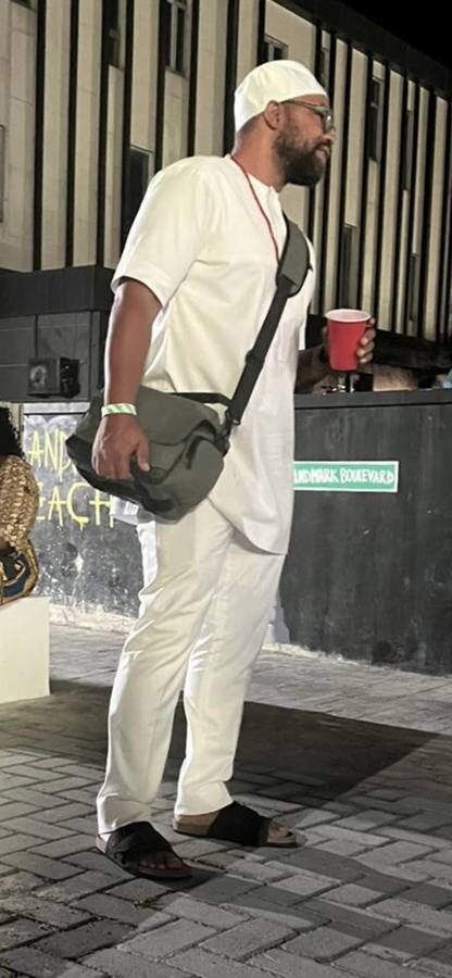 Eli Davis in white, standing on a street in Lagos, Nigeria