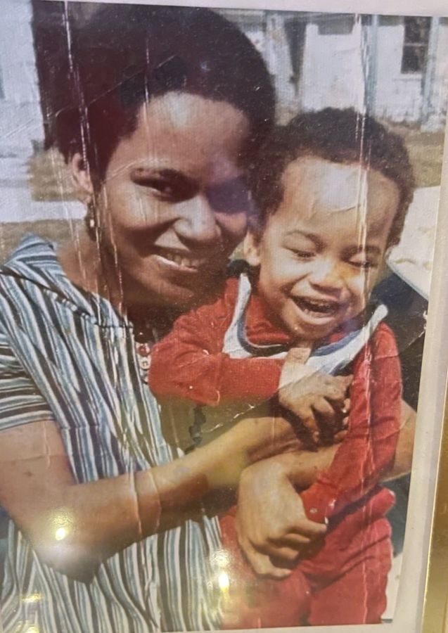 Eli's mother, Darcus, holding him as a child